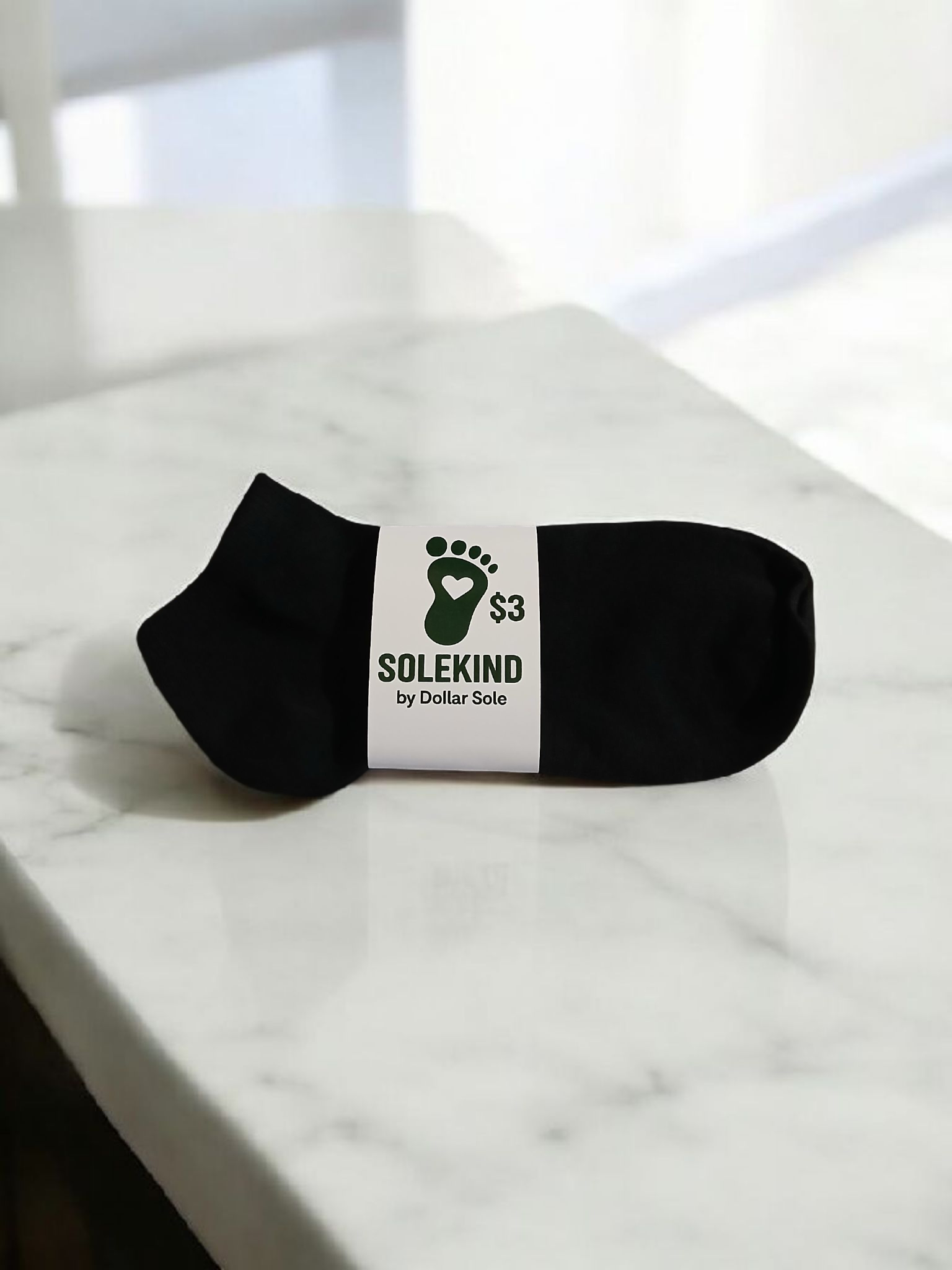 A pair of black polyester SoleKind ankle socks for men, shown folded or laid flat.