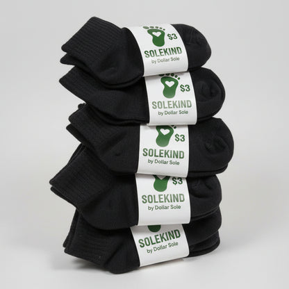Five pairs of black socks with 'Solekind' labels on a gray surface