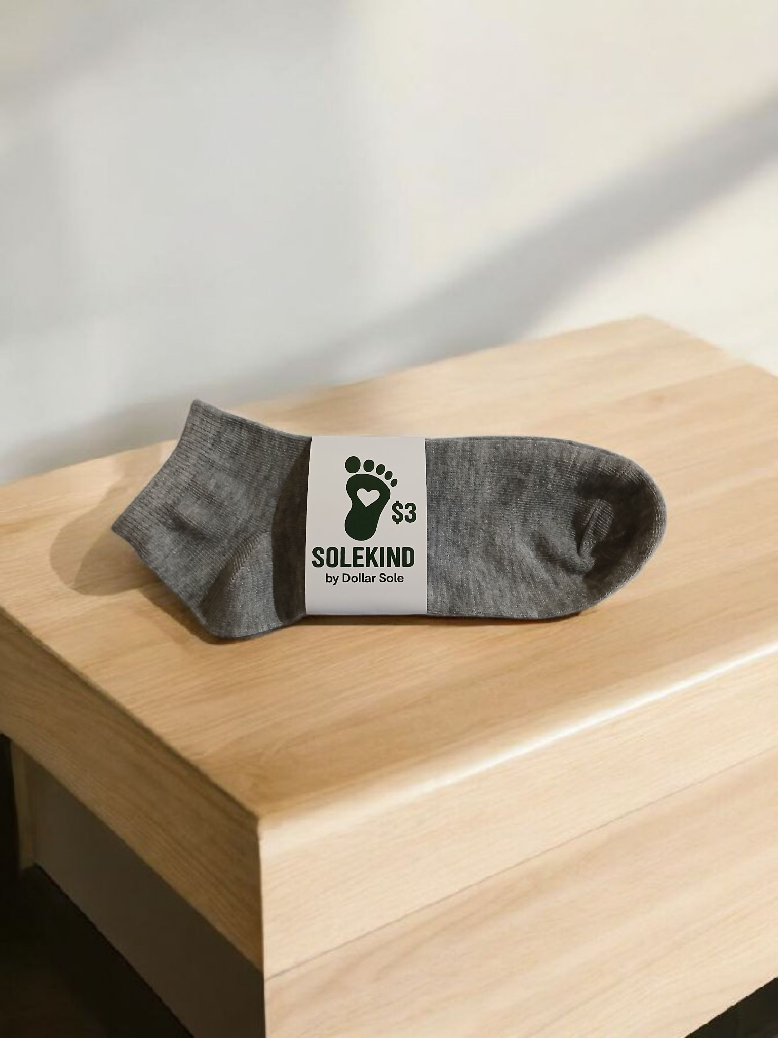 A pair of gray polyester SoleKind ankle socks for men, shown folded or laid flat.