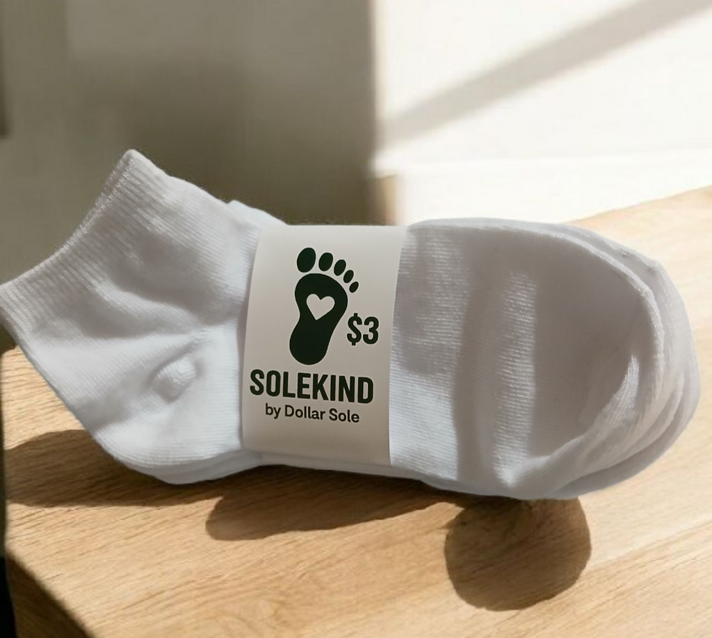 A pair of white polyester SoleKind ankle socks for men, shown folded or laid flat.