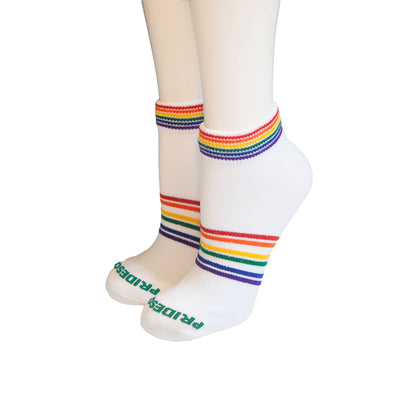 White socks with rainbow stripes worn by a person on a white background